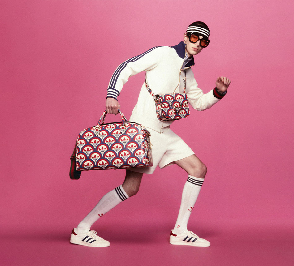 A man wearing short trousers and sunglasses is carrying an adidas x Gucci bag (Photo)