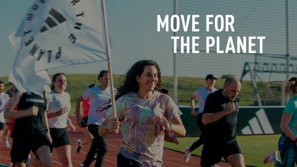 The image shows people, likely engaged in a race or running event, and in the background, there is a banner with text that reads "MOVE FOR THE PLANET." This suggests that the event is part of a campaign to encourage physical activity for environmental causes. 