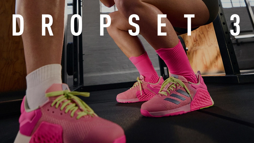 The image shows a promotional advertisement for a product called "DropSet 3," which seems to be associated with fitness or athletic wear. In the background, there is a person engaging in physical activity, possibly workout related given the text and items that resemble sports equipment or clothing. The foreground features an item of clothing, likely a gym or sports apparel, and some accessories like socks and a piece of sports equipment or trainer shoes.