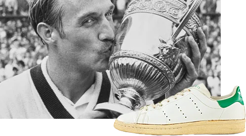 This picture shows an athlete kissing his throphy. It is a historical image. In the foreground, there is an adidas sneaker, possibly the one that he was wearing at the time of winning.