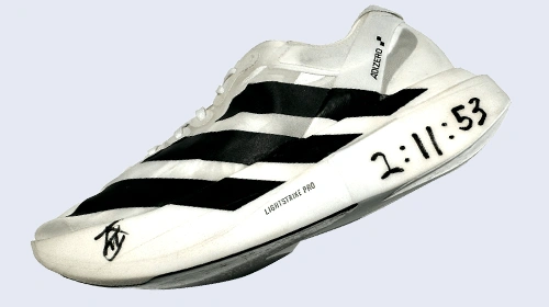 This is an image of a white and black sneaker displaying a shoe with digital time elements. 