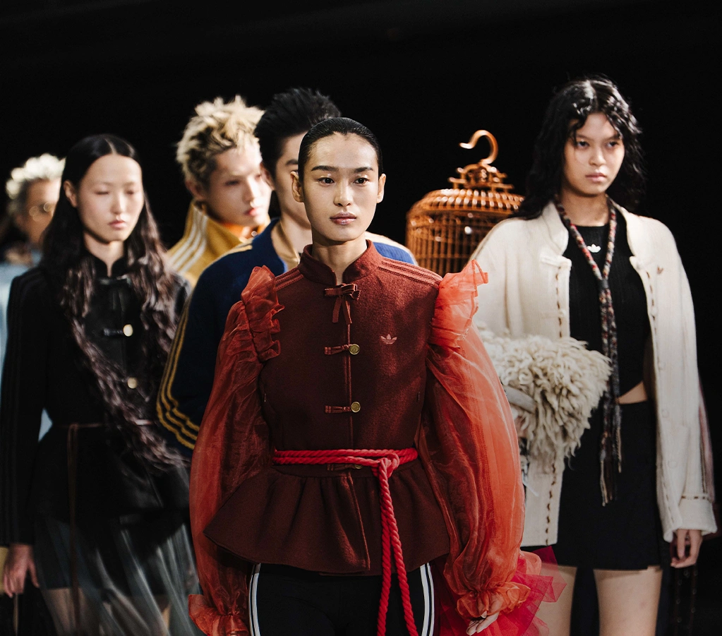 Weibliches Model trägt adidas Jacke im Außenbereich. (Foto)