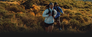 Zwei Läufer beim Trailrunning in bergiger Landschaft. (Foto)