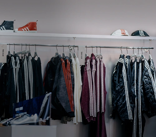 Selection of adidas apparel on a clothing rack. (Photo)