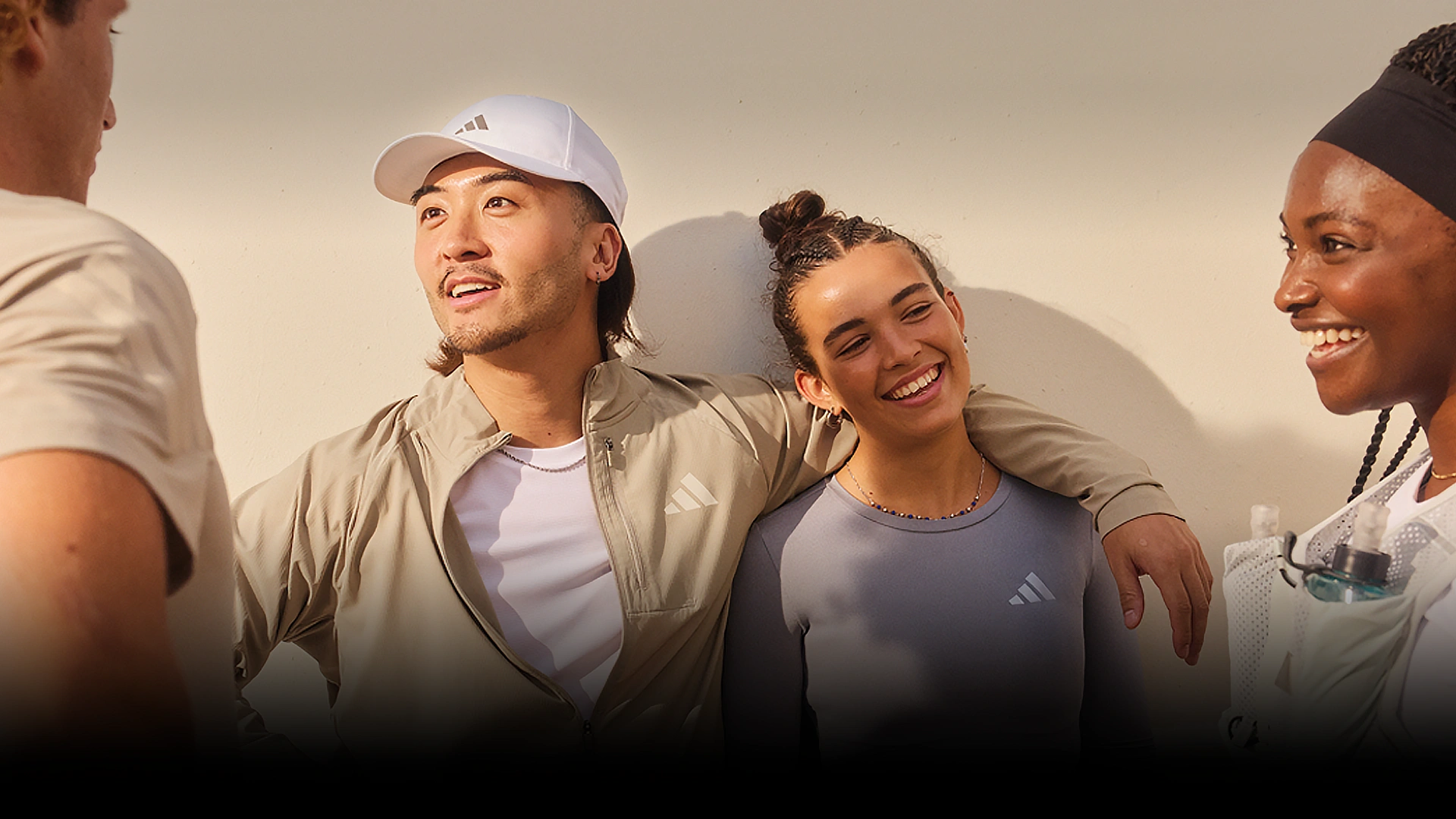 Group of young adults talking while wearing adidas sportswear. (Photo)