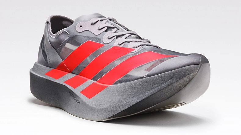 Grey running shoe with bold red stripes and a thick sole against a neutral background. (Photo)